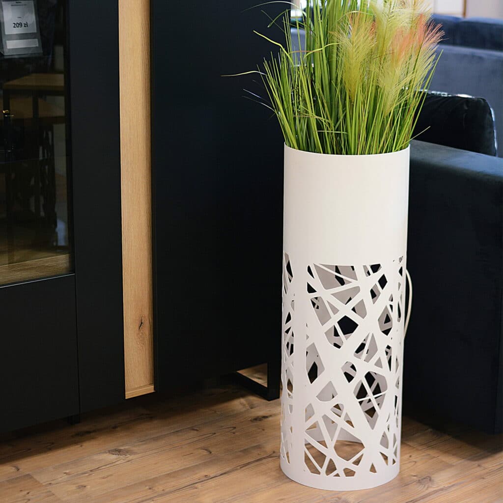 Biały kwietnik metalowy w pomieszczeniu